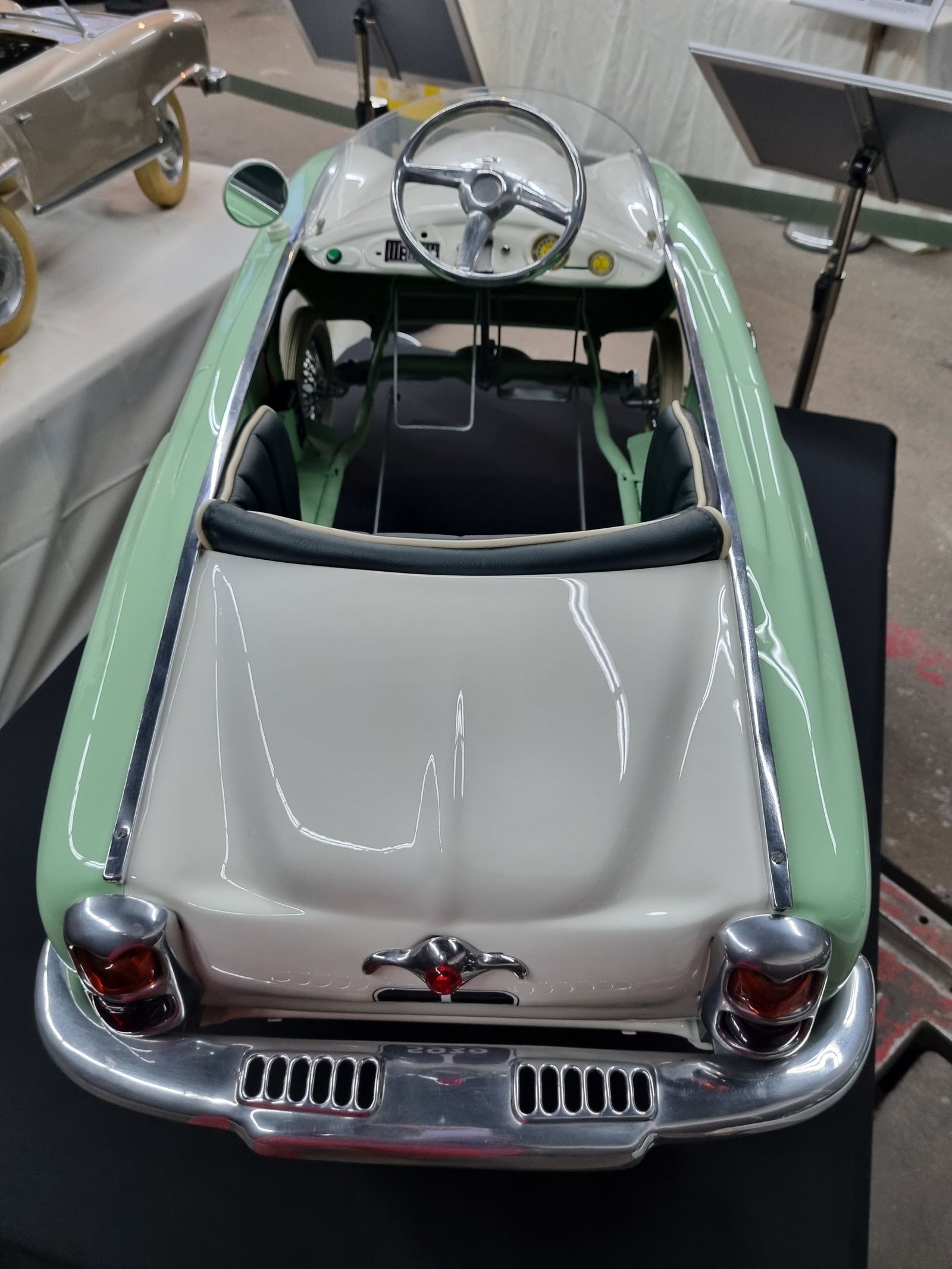 Ein grün-weißes Spielzeugauto steht auf einem Tisch